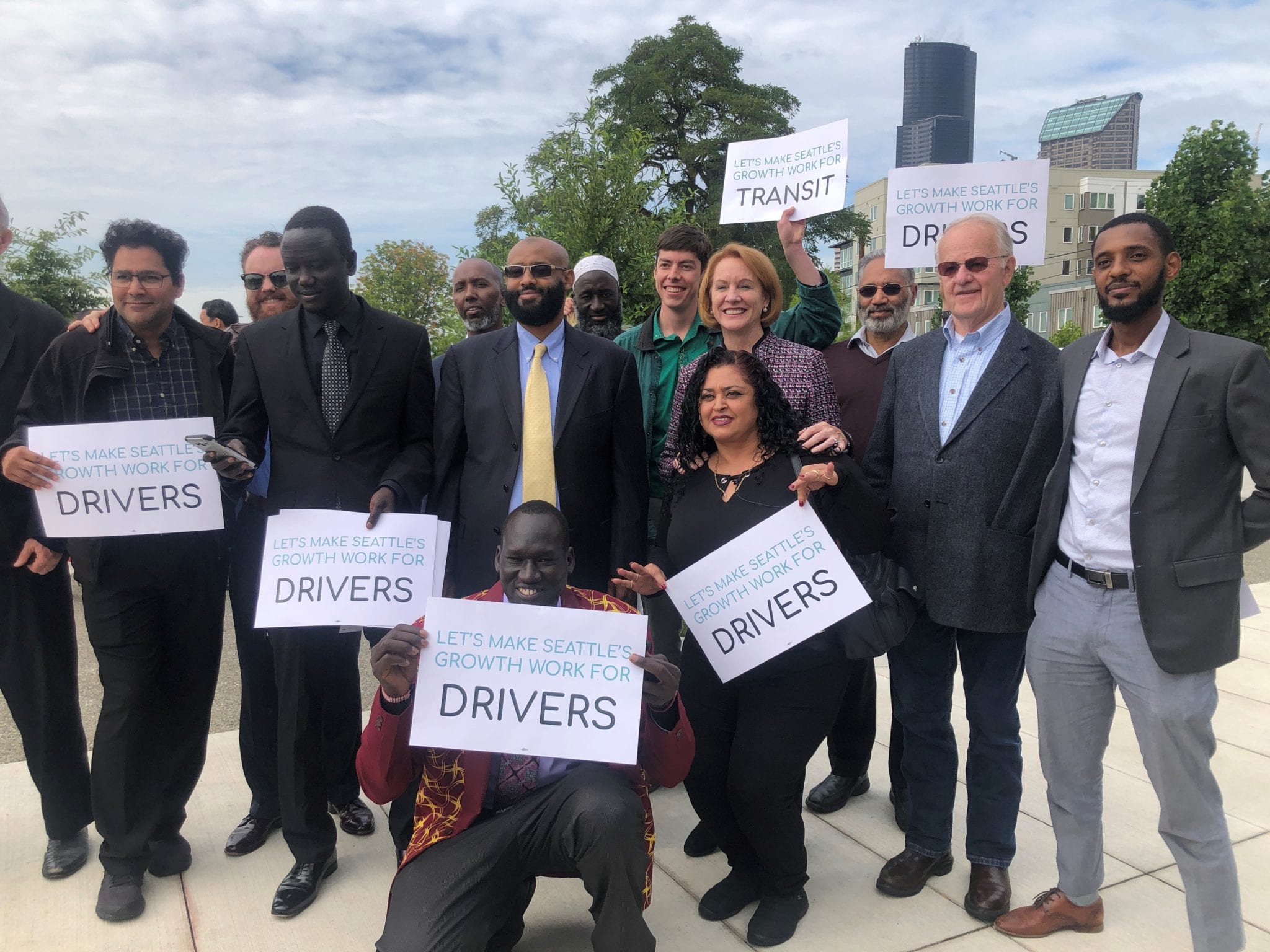 Mayor Durkan, surrounded by TNC drivers and community advocates after announcing her Fare Share legislation