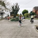 Young children ride their bikes around a roundabout in one of Seattle's Stay Healthy Streets
